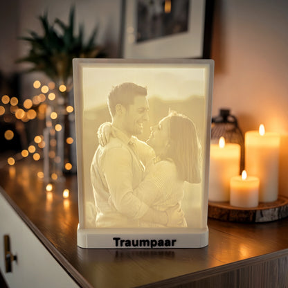 Foto-zu-3D-Litografie eines Paares als personalisiertes 3D-Bild mit Lichtwirkung und Sockel-Text „Traumpaar“, dekorativ mit Kerzen in warmem Ambiente inszeniert.